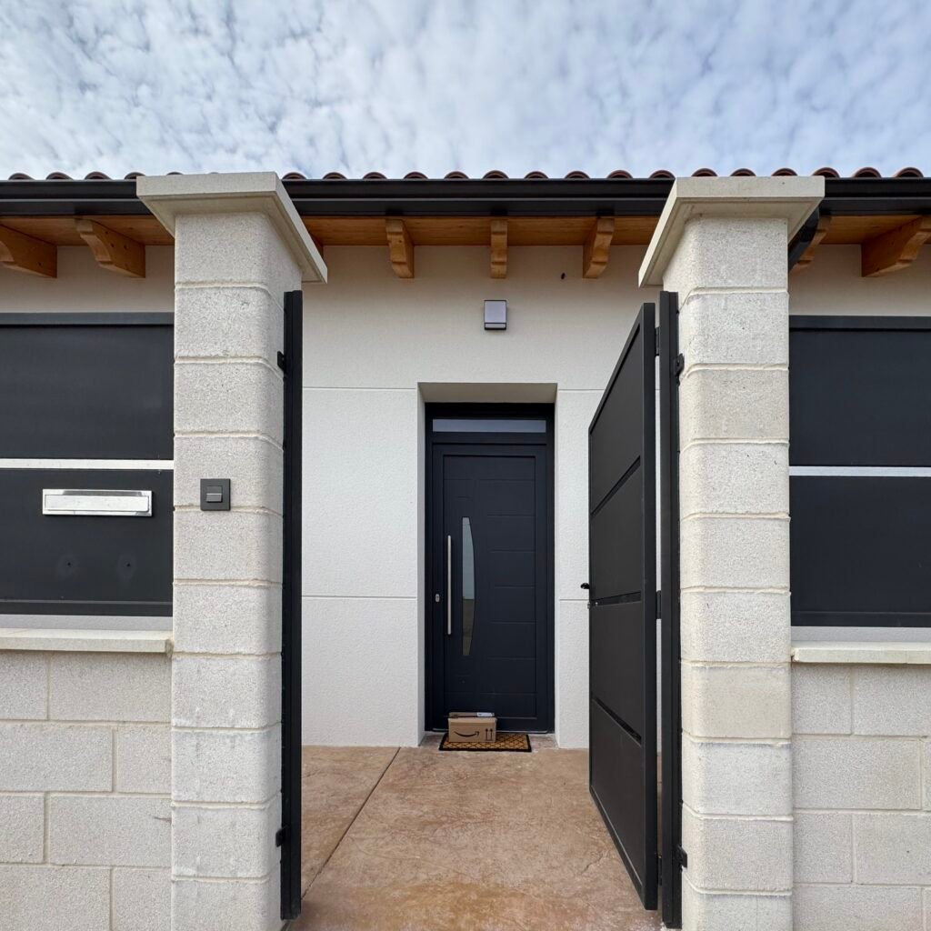 Entrada principal de vivienda unifamiliar en Villar del Yermo (León) Entrada principal de vivienda unifamiliar con puerta y cerramiento moderno en Villar del Yermo, León