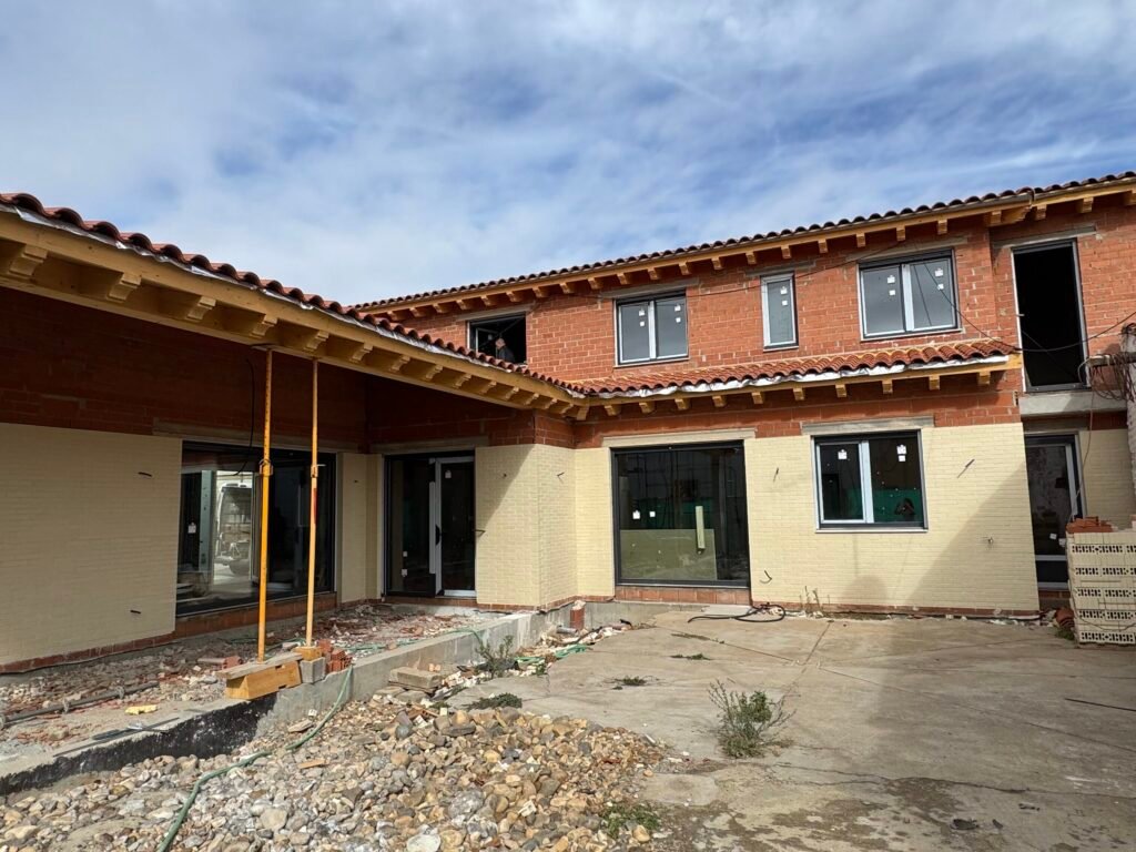 Vista general del patio y fachada de vivienda en obra en Laguna Dalga – Construcciones Prieto Vista general del patio exterior y fachada de vivienda en proceso de obra en Laguna Dalga realizada por Construcciones Prieto